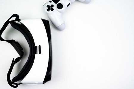 Top view of a virtual reality headset with a game controller on a white background. Having fun playing with itの写真素材
