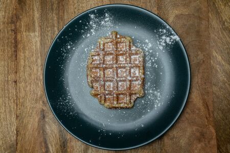 Homemade Belgian waffle on a plate. With powder sugar on it. Top viewの写真素材