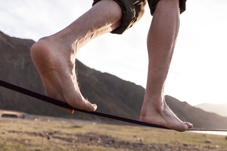 Man walking on the sling at sunsetの写真素材