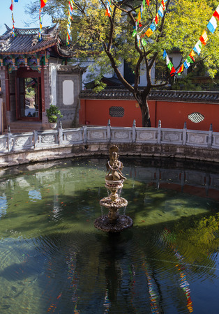 Beautiful Chinese garden with a pond and flagsの写真素材