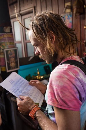 Serious male student reading a book in a libraryの写真素材