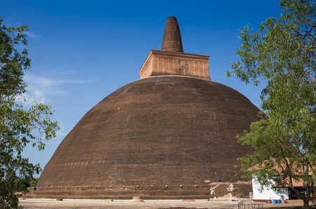 The rear of the Rankoth Vehera, the largest Buddhist stupa at the ruins of the ancient kingdom capitol of Polonnaruwa, Sri Lankaの写真素材
