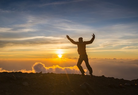Man jump through the gap on sunset fiery background. Element of  design.の写真素材