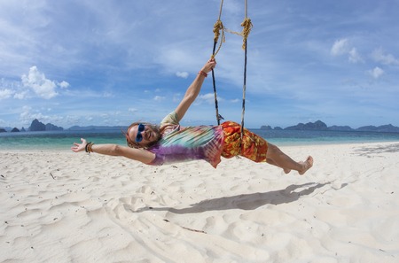 Businessman swinging at tropical beach in Philippinesの写真素材