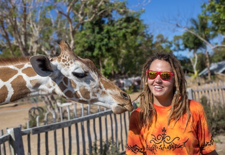 Girl Feeding Giraffe at national park in Philippinesの写真素材