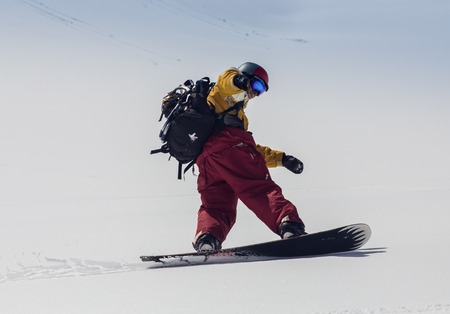 Mountaineer reaches the top of a snowy mountain in a sunny winter day. Alps, Italy.の写真素材