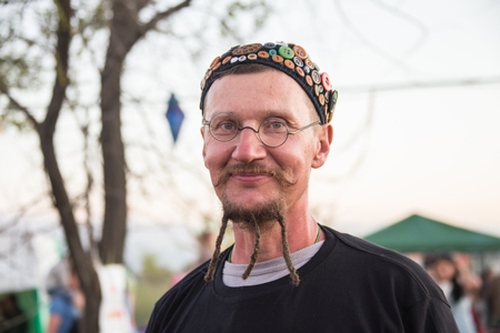 Cosmos Village, Almaty Province, Kazakhstan - 16 August 2015: The festival of ethnic music Forey, a lot of people gathers on this holiday to relax and have  fun. Ethnic open-air concert, where many people gathered. Portrait  of a young smiling man on holiのeditorial素材