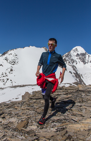 AKTRU,KURDAI,GORNII ALTAI / KAZAKHSTAN - JUNE 10: International Championship in the discipline skyrunning "Aktru 2016". Athletes from different countries compete in the championship in a very beautiful mountains of Altai. A strong man runs up to the titleのeditorial素材