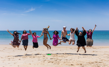 THAILAND/PHUKET - MARCH 8 2016: group of happy young people dancing and spraying at the beach on beautiful summer sunset.のeditorial素材