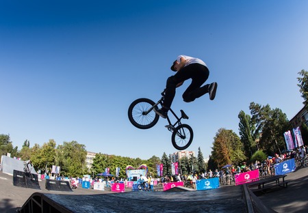 KAZAKHSTAN ALMATY - AUGUST 28, 2016: Urban extreme competition, where the city athletes compete in the disciplines: skateboard, roller skates, BMX. Bmx stunt performed at the top of a mini ramp on a skateparkのeditorial素材