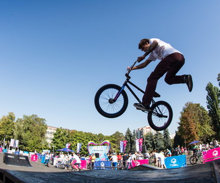 KAZAKHSTAN ALMATY - AUGUST 28, 2016: Urban extreme competition, where the city athletes compete in the disciplines: skateboard, roller skates, BMX. Bmx stunt performed at the top of a mini ramp on a skateparkのeditorial素材