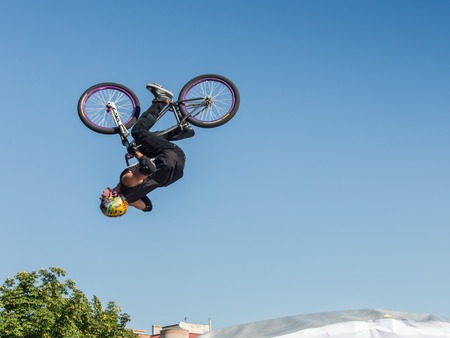 KAZAKHSTAN ALMATY - AUGUST 28, 2016: Urban extreme competition, where the city athletes compete in the disciplines: skateboard, roller skates, BMX. Bmx stunt performed at the top of a mini ramp on a skateparkのeditorial素材