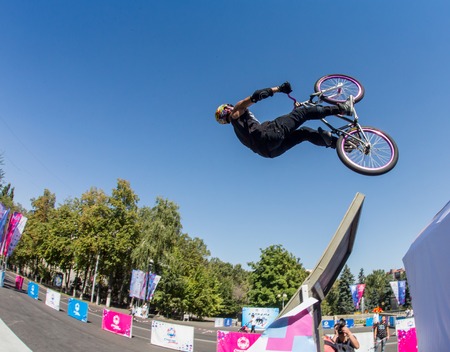 KAZAKHSTAN ALMATY - AUGUST 28, 2016: Urban extreme competition, where the city athletes compete in the disciplines: skateboard, roller skates, BMX. Bmx stunt performed at the top of a mini ramp on a skateparkのeditorial素材