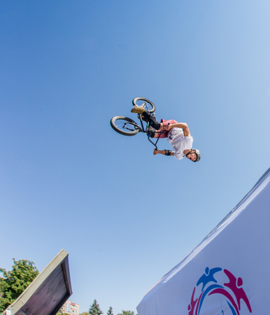 KAZAKHSTAN ALMATY - AUGUST 28, 2016: Urban extreme competition, where the city athletes compete in the disciplines: skateboard, roller skates, BMX. Bmx stunt performed at the top of a mini ramp on a skatepark KAZAKHSTAN ALMATY - AUGUST 28, 2016: Urban extreme competition, where the city athletes compete in the disciplines: skateboard, roller skates, BMX. Bmx stunt performed at the top of a mini ramp on a skatepark