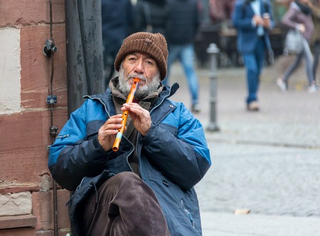 GERMANY, FRANKFURT: 12 DECEMBER 2016 - European street musicians who sitting on the pedestrian streets and playing music for charity.のeditorial素材
