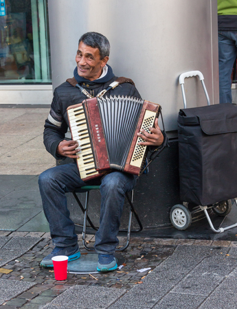 GERMANY, FRANKFURT: 12 DECEMBER 2016 - European street musicians who sitting on the pedestrian streets and playing music for charity.のeditorial素材