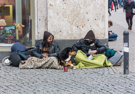 GERMANY, FRANKFURT: 12 DECEMBER 2016 - Young and dirty beggar asking for some money on city river bankのeditorial素材