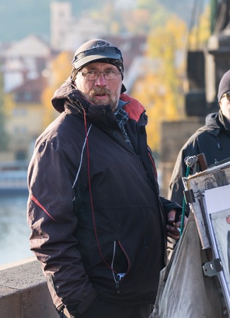 GERMANY, FRANKFURT: 12 DECEMBER 2016 - Serious handsome hipster man in winter clothes leaning on the concrete wall boxのeditorial素材