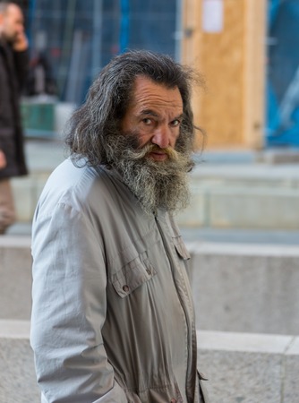 GERMANY, FRANKFURT: 12 DECEMBER 2016 - Serious handsome hipster man in winter clothes leaning on the concrete wall boxのeditorial素材