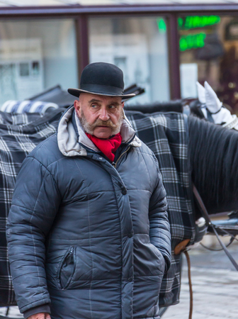 GERMANY, FRANKFURT: 12 DECEMBER 2016 - Serious handsome hipster man in winter clothes leaning on the concrete wall boxのeditorial素材