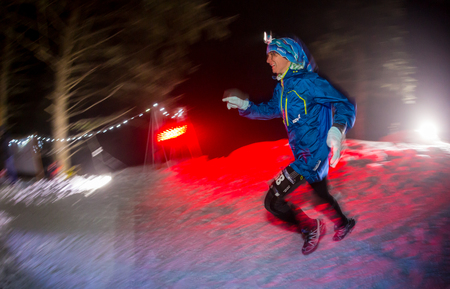 ALMATY, KAZAKHSTAN - 18 FEBRUARY 2017: Night competitions in the foothills of the city of Almaty, in the Trailrunning and Skyship discipline, which is called TunRun winter edition. Man running in the mountains at nightのeditorial素材