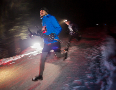 ALMATY, KAZAKHSTAN - 18 FEBRUARY 2017: Night competitions in the foothills of the city of Almaty, in the Trailrunning and Skyship discipline, which is called TunRun winter edition. Man running in the mountains at nightのeditorial素材