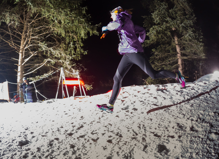 ALMATY, KAZAKHSTAN - 18 FEBRUARY 2017: Night competitions in the foothills of the city of Almaty, in the Trailrunning and Skyship discipline, which is called TunRun winter edition. Man running in the mountains at nightのeditorial素材