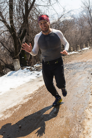ALMATY, KAZAKHSTAN - APRIL 09, 2017: Amateur competitions - Mountain half-marathon, in the foothills of Almaty, on the Yunat lakes. Athletic young man running in the nature. Healthy lifestyleのeditorial素材
