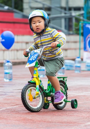 KAZAKHSTAN, ALMATY - JUNE 11, 2017: Childrens cycling competitions Tour de kids. Children aged 2 to 7 years compete in the stadium and receive prizes. A little boy rides a bike and competes to become a winner.のeditorial素材