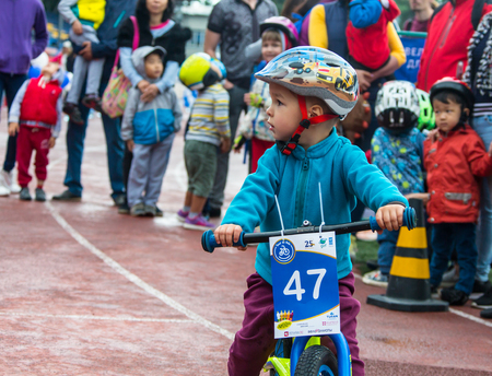 KAZAKHSTAN, ALMATY - JUNE 11, 2017: Childrens cycling competitions Tour de kids. Children aged 2 to 7 years compete in the stadium and receive prizes. A little boy rides a bike and competes to become a winner.のeditorial素材