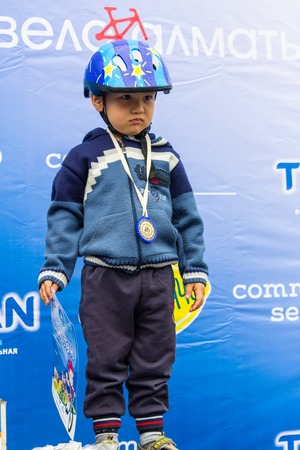KAZAKHSTAN, ALMATY - JUNE 11, 2017: Childrens cycling competitions Tour de kids. Children aged 2 to 7 years compete in the stadium and receive prizes. Excited boy and girls with medalsのeditorial素材