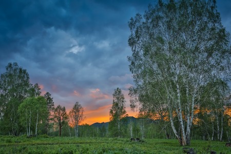 Beautiful dramatic sunset in the mountains. Landscape with sun light shining through orange cloudsの写真素材