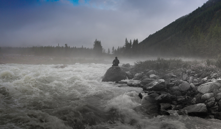 Silhouette of a man in the darkness. Night Photography. Dense fog over the river.の写真素材