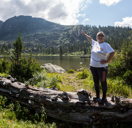 ERGAKI, RUSSIA - AUGUST 05 2017: An unknown elderly woman walks the mountains, a participant in the TRAILING contest SKAYRANFEST August 5, 2017 in the Ergaki National Park, Russia.のeditorial素材