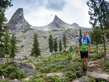 ERGAKI, RUSSIA - AUGUST 05 2017: An unknown male athlete runs through the mountains, a participant in the TRAILANNING competition SKAYRANFEST August 5, 2017 in the Ergaki National Park, Russia.のeditorial素材