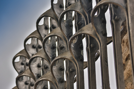 Beautiful wrought fence. Image of a decorative cast iron fence. metal fence close up. Metal Forged Fence. beautiful fence with artistic forgingの写真素材