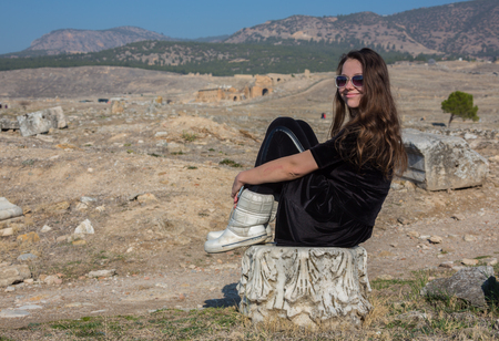 Beautiful Greek young girl holding an ancient vessel in ancient theatre of Thassos island, Greeceの写真素材