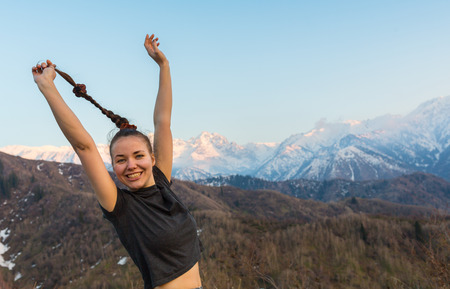 Carefree Happy Woman Enjoying Nature on grass meadow on top of mountain cliff with sunrise. Beauty Girl Outdoor.の写真素材