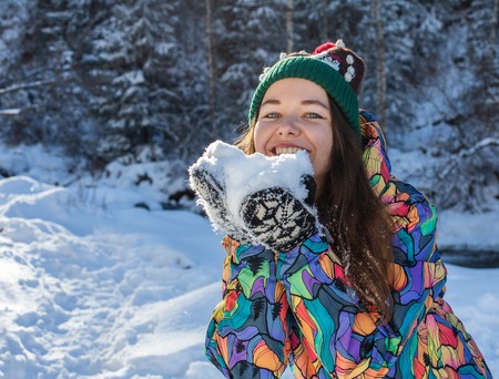 Christmas girl outdoor portrait. Winter woman blowing snow in a parkの写真素材