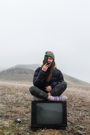 girl in the steppe sitting on the TV.の写真素材