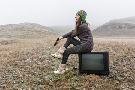 girl in the steppe sitting on the TV.の写真素材
