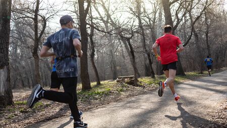 ALMATY KAZAKHSTAN - MARCH 16 2019: An unidentified man runs through a grove during the spring...