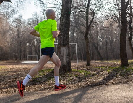 ALMATY KAZAKHSTAN - MARCH 16 2019: An unidentified man runs through a grove during the spring...