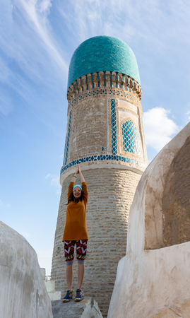 The girl on the roof of the mosque Chekminar - four minarets, in the city of Bukhara, Uzbekistanの写真素材