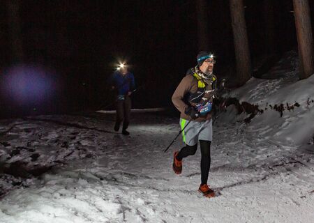 ALMATY KAZAKHSTAN: FEBRUARY 15, 2020: Unidentified people run at winer night in the mountains near the city of Almaty with flashlights during the night run of TunRun Limitedのeditorial素材
