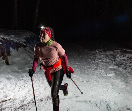ALMATY KAZAKHSTAN: FEBRUARY 15 2020: Unidentified girls run at night in the winter in the mountains near the city of Almaty with flashlights during the night run of TunRun Limited on February 15, 2020のeditorial素材