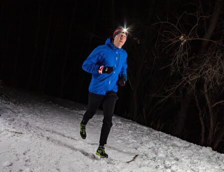 ALMATY KAZAKHSTAN: FEBRUARY 15, 2020: Unidentified people run at winer night in the mountains near the city of Almaty with flashlights during the night run of TunRun Limitedのeditorial素材