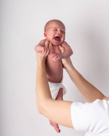 Portrait of a screaming newborn hold at hands, family, healthy birth concept photo, close upの写真素材