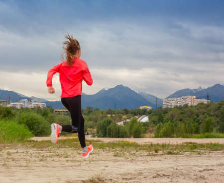 Running in city park. Woman runner outside jogging with Montreal skyline in background.の写真素材