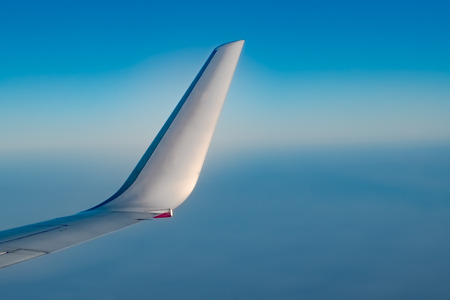 Beautiful photo of Winglet of an Airplane, taken from the window side, during air travel at very high Altitude with crystal clear Blue atmosphere outside the window.の写真素材